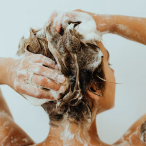 femme brune fesant un shampoing